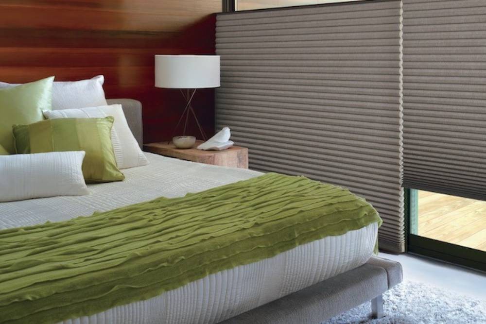 Bedroom with green throw on the bed. Large Duette shades in the window near Stuart, FL